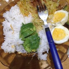 A picture of Cococut rice served with steamed cabbage, hard boiled eggs and avocado.