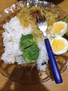 A picture of Cococut rice served with steamed cabbage, hard boiled eggs and avocado.