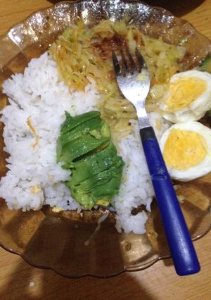 A picture of Cococut rice served with steamed cabbage, hard boiled eggs and avocado.