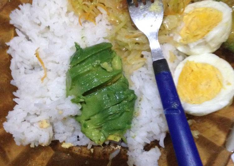 Cococut rice served with steamed cabbage, hard boiled eggs and avocado