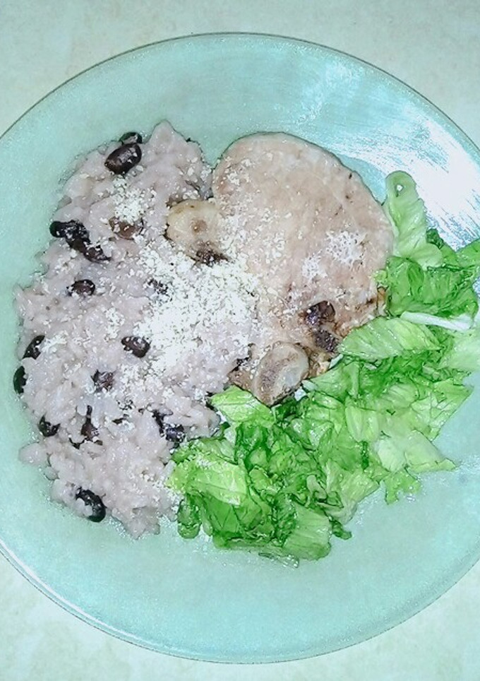 Una foto de Costeleta de cerdo con ensalada de porotos, arroz y lechuga