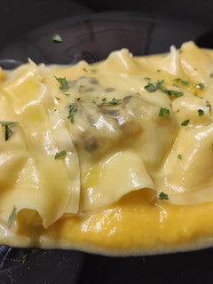 Una foto de Raviolis de wonton rellenos de langostinos, chalota y puerro con crema de calabaza asada