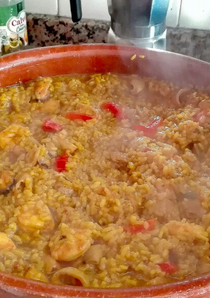 Una foto de Paella de arroz redondo con sepia y calamares