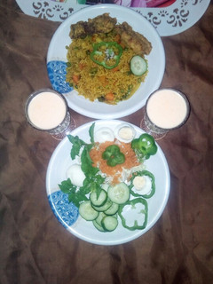 A picture of Fried rice with victoria chicken and salad.