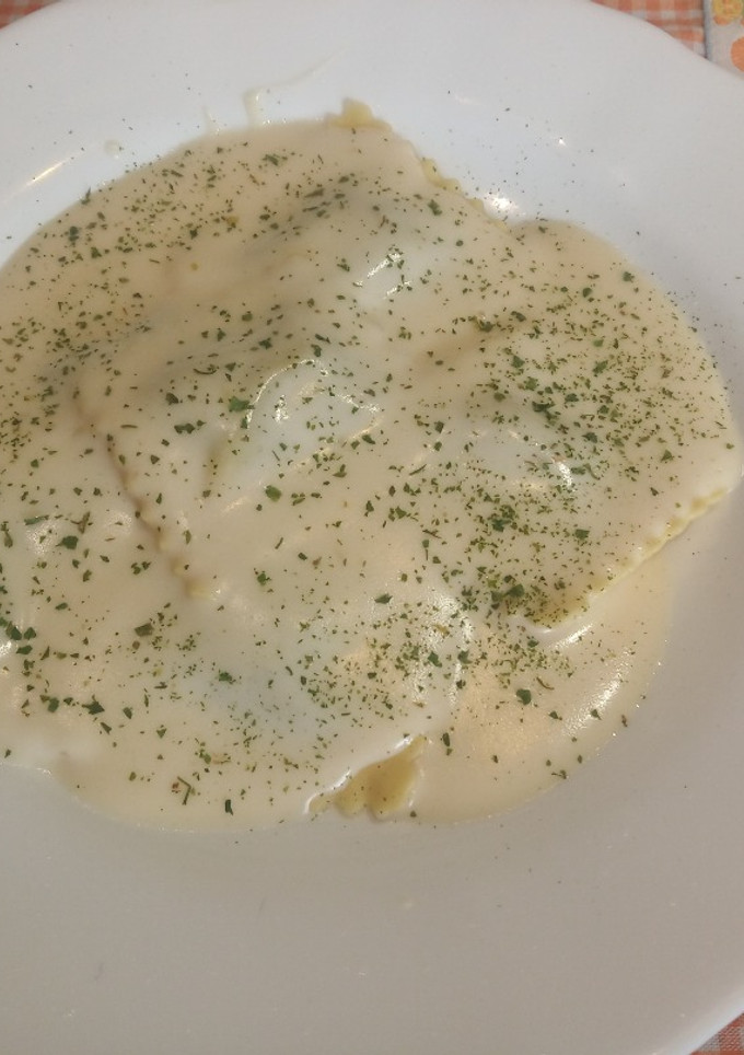 Una foto de Pasta fresca al huevo rellena de Ricota y Espinacas con salsa de queso