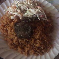 A picture of Jollof rice with beef and salad.