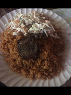 A picture of Jollof rice with beef and salad.