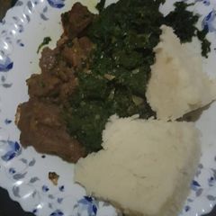 A picture of Dry fry beef served with greens and ugali.