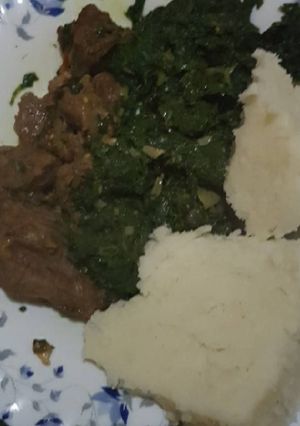 A picture of Dry fry beef served with greens and ugali.
