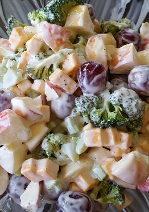 Una foto de Ensalada con uvas, manzanas, brócoli y queso amarillo
