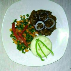 A picture of Carbonnade of beef with mashed potatoes and mixed vegetables.