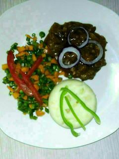 A picture of Carbonnade of beef with mashed potatoes and mixed vegetables.