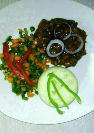 A picture of Carbonnade of beef with mashed potatoes and mixed vegetables.