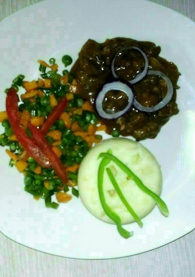 A picture of Carbonnade of beef with mashed potatoes and mixed vegetables.