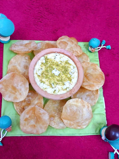 A picture of Rice kheer with soft and fluffy puris.