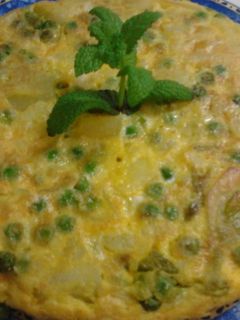 Una foto de Tortilla de guisantes, cebolletas tiernas, y patatas a la hierbabuena