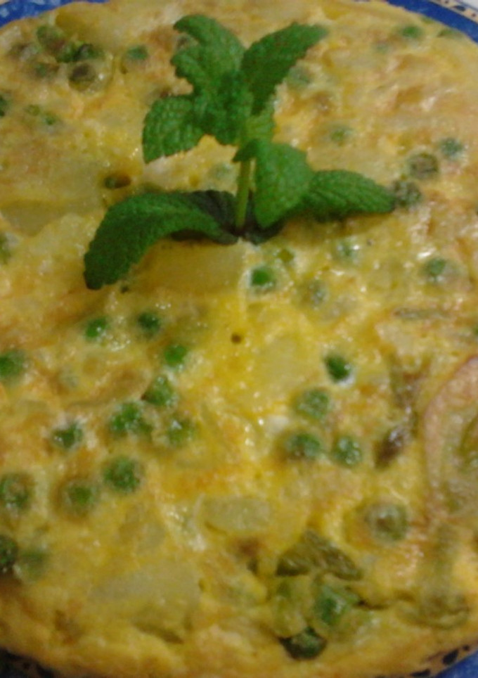 Una foto de Tortilla de guisantes, cebolletas tiernas, y patatas a la hierbabuena