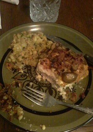 A picture of Parmesan crusted pork chops w/bacon bits and garlic mushrooms.
