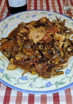 Una foto de Emperador con cebolla caramelizada, champiñones rodajas de tomate con un toque de vino blanco