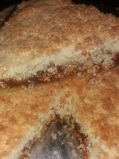 Una foto de Torta rellena de dulce de leche con cubierta de crumble de coco