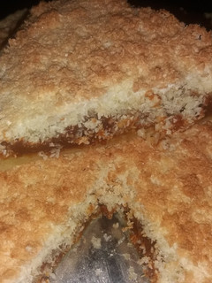 Una foto de Torta rellena de dulce de leche con cubierta de crumble de coco
