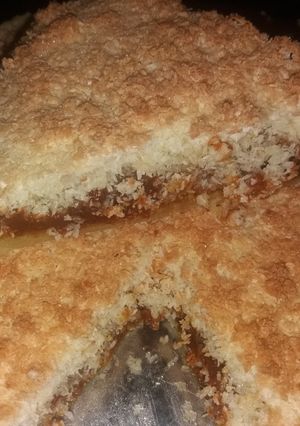 Una foto de Torta rellena de dulce de leche con cubierta de crumble de coco