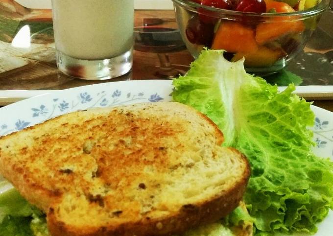 Egg sandwich with fruit salad and almond pumpkin seeds milkshake