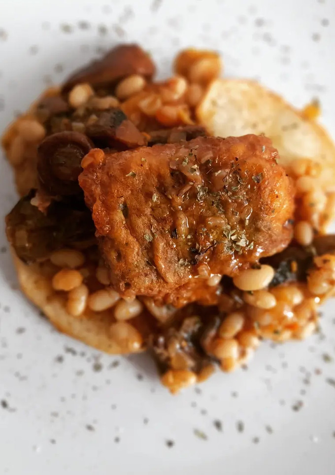 Una foto de Merluza rebozada con fessolets y rovellons a la sobrasada