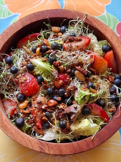 Una foto de Ensalada verde con fresas, arándanos y granola salada