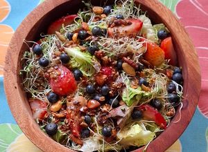 Una foto de Ensalada verde con fresas, arándanos y granola salada