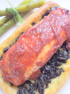 Una foto de Salmón con salsa roja y espinacas