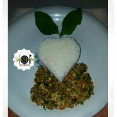 A picture of White rice with egg sauce/scramble egg/omellete and spinach.