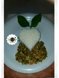A picture of White rice with egg sauce/scramble egg/omellete and spinach.