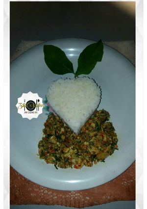A picture of White rice with egg sauce/scramble egg/omellete and spinach.