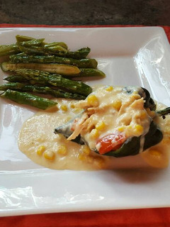 Una foto de Chiles rellenos de pollo, bañados en salsa de elote