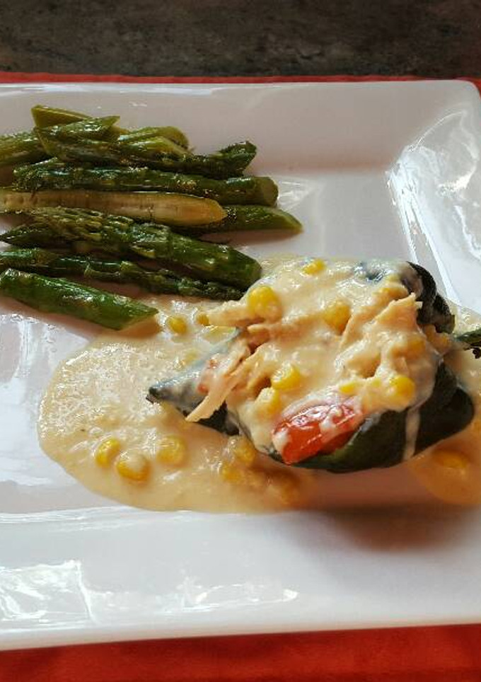 Una foto de Chiles rellenos de pollo, bañados en salsa de elote