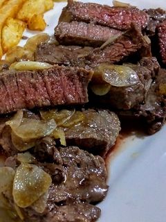 Una foto de LOMITO De Res al Ajillo, término Azul con Papas Fritas