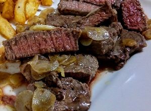 Una foto de LOMITO De Res al Ajillo, término Azul con Papas Fritas