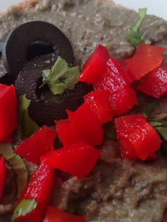 Una foto de Hummus de lentejas, aceitunas negras y cilantro con Agua de Mar