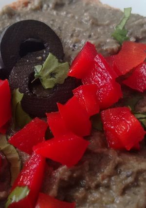 Una foto de Hummus de lentejas, aceitunas negras y cilantro con Agua de Mar