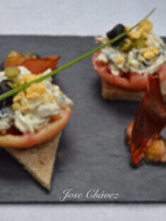 Una foto de Tostas de tomate confitado y pollo