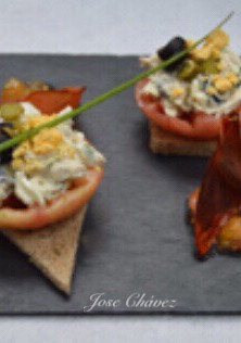 Una foto de Tostas de tomate confitado y pollo