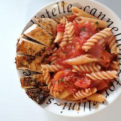 A picture of Cajun chicken and tomato pasta.