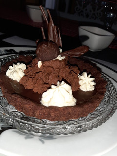 A picture of Mini chocolate tart with ganache topping and fresh cream.