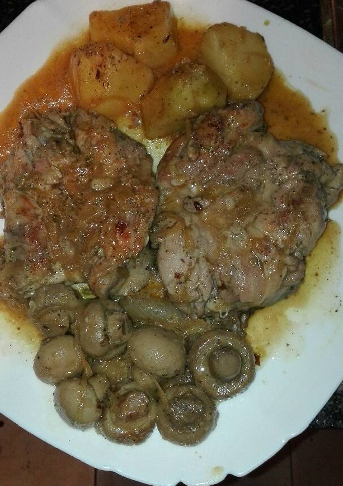 Una foto de muslo de pollo dehuesado encebollado con patatas y champiñones