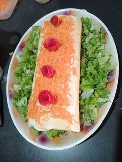 Una foto de Pionono de atún con jamón, queso, tomates y lechuga