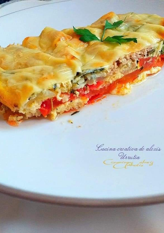 Una foto de Tomates con huevos, cebollas y atún con costra de queso
