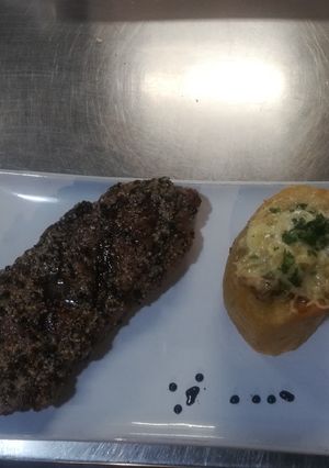 Una foto de Bife de chorizo al whisky, manteca de pimienta y risotto de papa