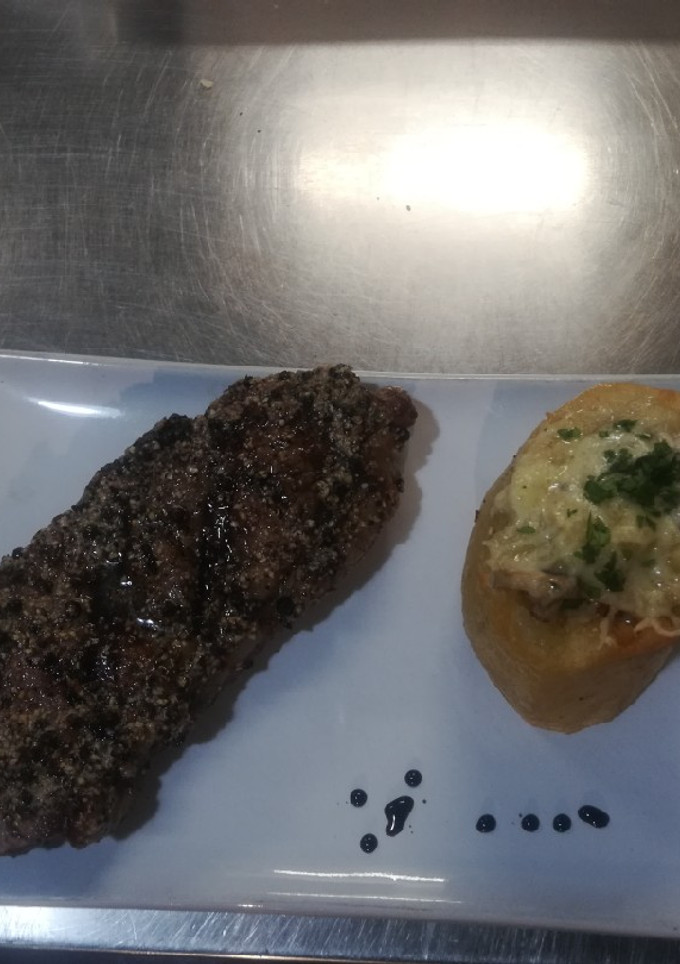 Una foto de Bife de chorizo al whisky, manteca de pimienta y risotto de papa