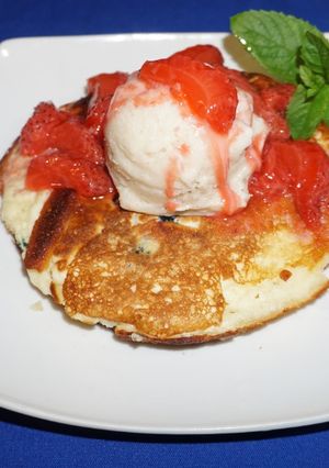 A picture of Ripe Banana Ice Cream over Pancakes with Strawberry Sauce.